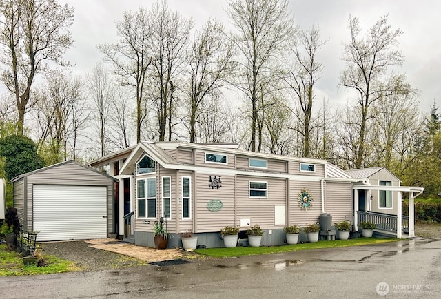 view of front of home featuring a garage, driveway, and an outbuilding