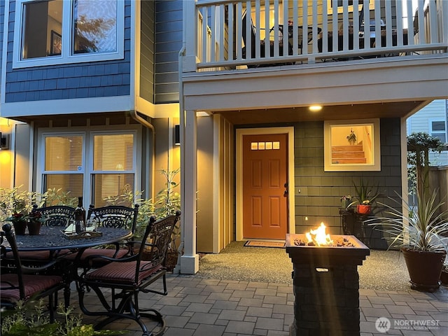 doorway to property featuring outdoor dining space, a patio, and a balcony