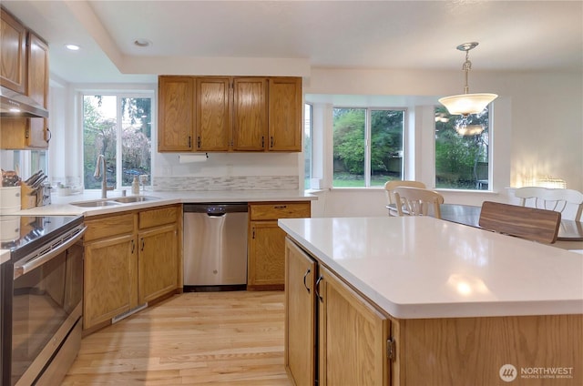 9410 175th Street Ct E, Puyallup, WA 98375 - kitchen featuring decorative light fixtures, a sink, light countertops, light wood-style floors, and stainless steel appliances