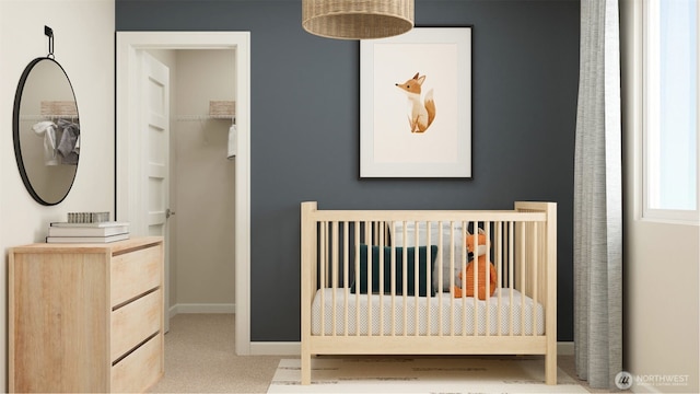 unfurnished bedroom featuring a spacious closet, baseboards, and carpet floors