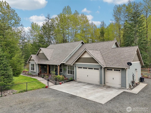 view of front of house with concrete driveway, fence private yard, a porch, roof with shingles, and a garage