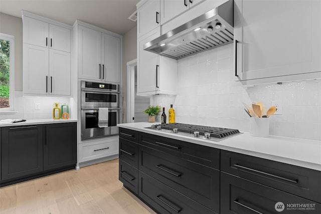 18122 83rd Ave NE, Kenmore, WA 98028 - kitchen with tasteful backsplash, light countertops, white cabinets, under cabinet range hood, and stainless steel appliances