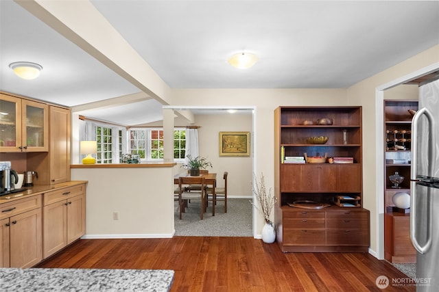 kitchen with dark wood finished floors, glass insert cabinets, freestanding refrigerator, and lofted ceiling with beams