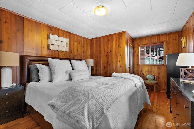 bedroom with wooden walls and wood finished floors