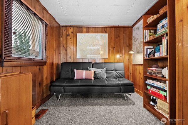 interior space with wood walls, carpet flooring, and visible vents