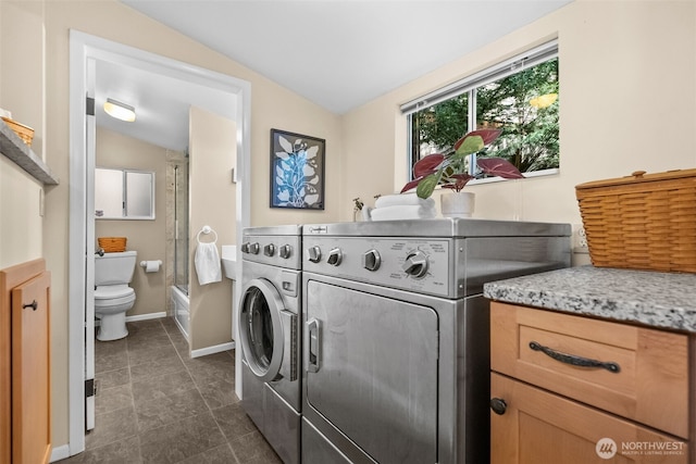 laundry area with separate washer and dryer and baseboards