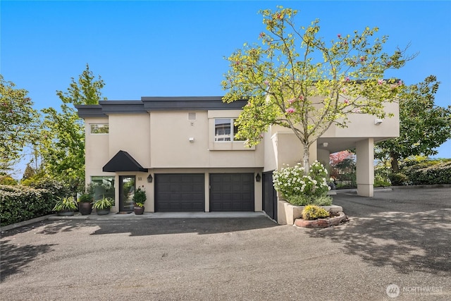 view of front of home with stucco siding, aphalt driveway, and an attached garage