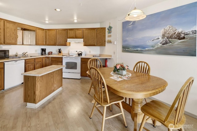 7806 Birch Bay Dr Unit 1107, Blaine, WA 98230 - kitchen featuring white appliances, under cabinet range hood, light wood-style floors, brown cabinetry, and a sink