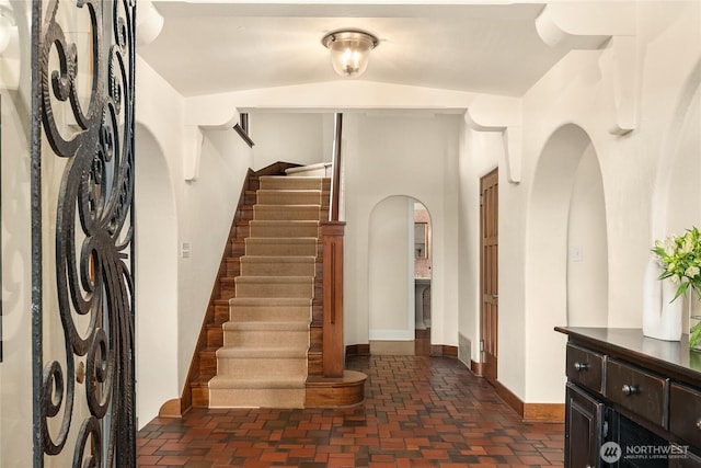 1919 Shenandoah Dr E, Seattle, WA 98112 - foyer featuring arched walkways, stairway, brick floors, and baseboards