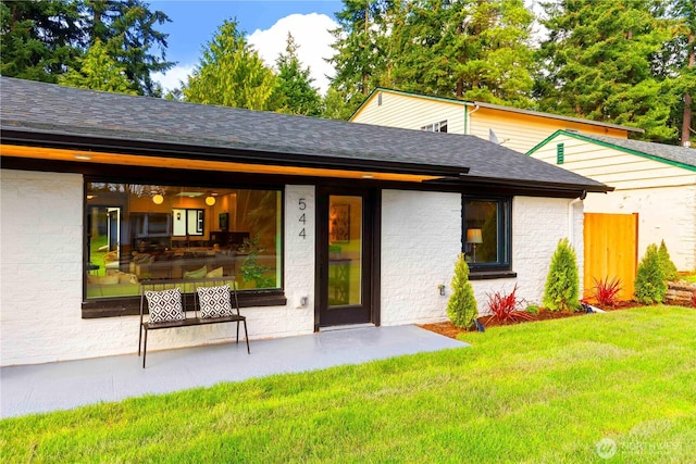 view of front of property with brick siding, roof with shingles, and a front lawn
