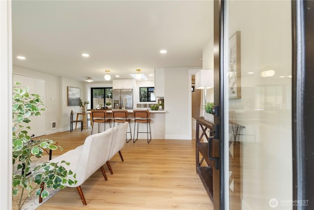 interior space featuring visible vents, baseboards, light wood finished floors, and recessed lighting