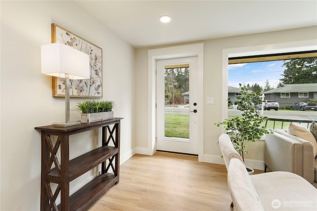 doorway to outside featuring light wood-style flooring, recessed lighting, and baseboards