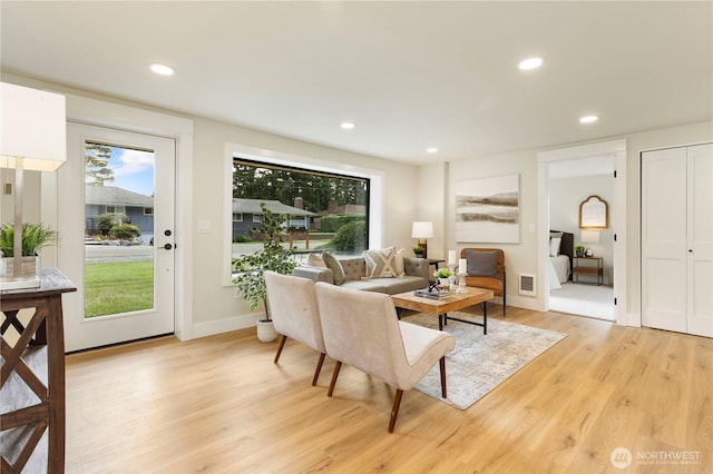 living area with visible vents, baseboards, light wood-type flooring, and recessed lighting