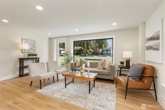 living area featuring light wood-style flooring, baseboards, visible vents, and recessed lighting