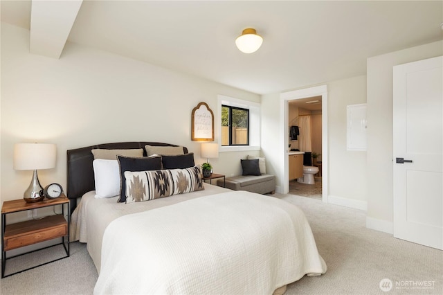 carpeted bedroom featuring baseboards and connected bathroom