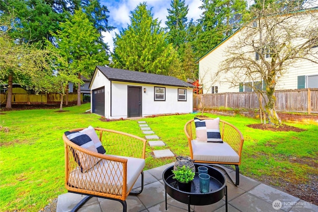 view of patio / terrace featuring a fenced backyard, an outdoor structure, and a garage