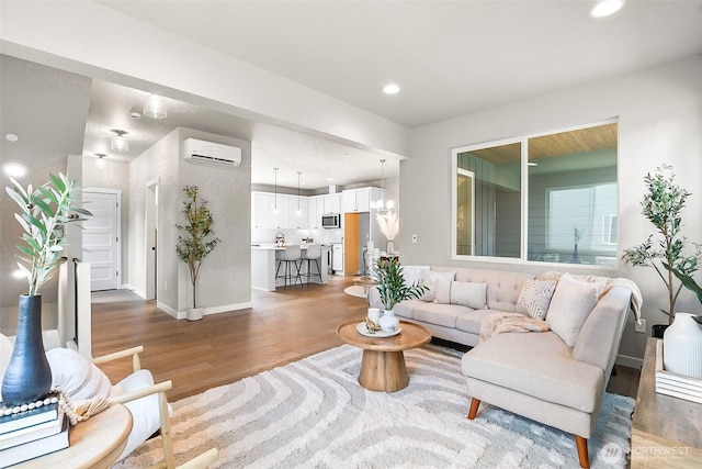 living area with baseboards, a wall mounted AC, recessed lighting, and wood finished floors