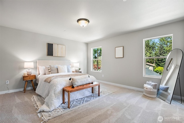 bedroom featuring baseboards, light colored carpet, and multiple windows