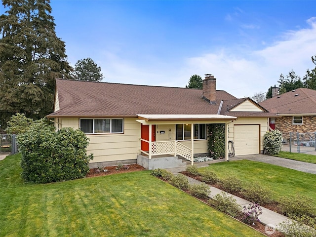 ranch-style home featuring a front lawn, a garage, fence, and aphalt driveway