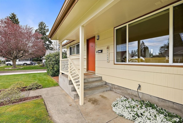 doorway to property with a lawn