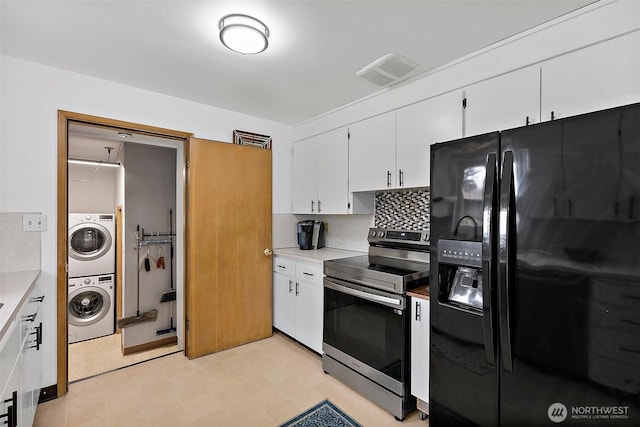 kitchen featuring stainless steel range with electric stovetop, black refrigerator with ice dispenser, white cabinets, stacked washer / dryer, and visible vents