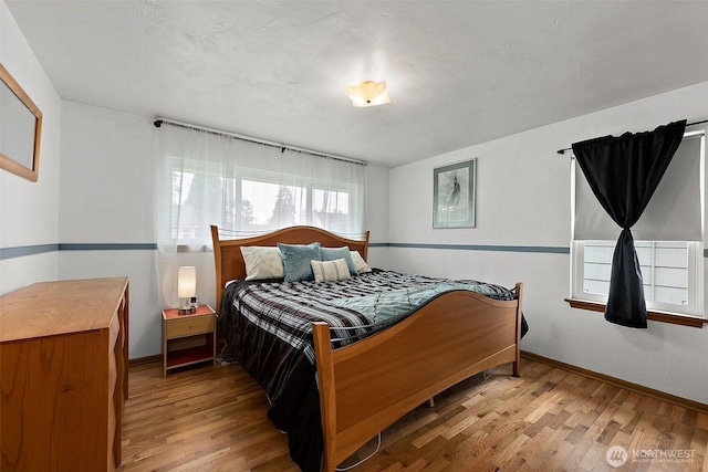 bedroom featuring baseboards and wood finished floors