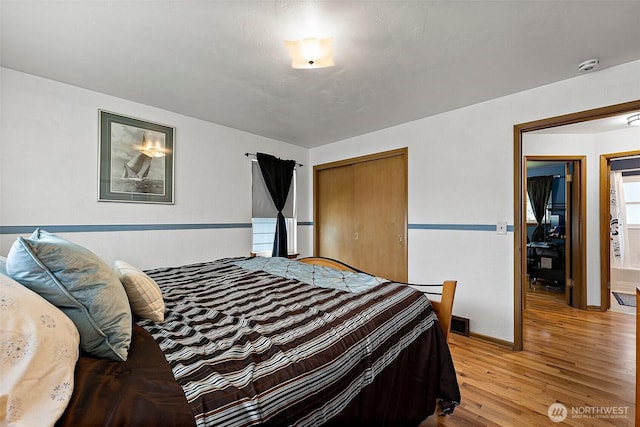 bedroom featuring a closet, baseboards, and wood finished floors