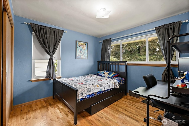 bedroom with baseboards and wood finished floors