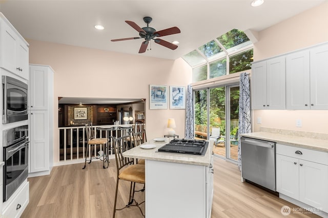 24507 SE 37th St, Sammamish, WA 98029 - kitchen featuring appliances with stainless steel finishes, white cabinets, ceiling fan, light wood-style flooring, and recessed lighting
