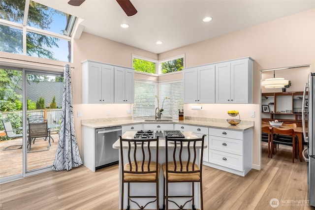 24507 SE 37th St, Sammamish, WA 98029 - kitchen with appliances with stainless steel finishes, a ceiling fan, light wood-style flooring, a sink, and light stone counters