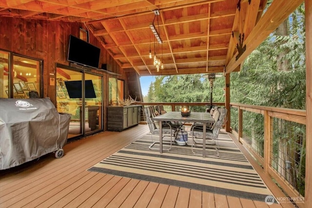 wooden terrace with area for grilling and outdoor dining area