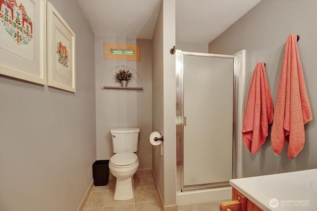 bathroom with tile patterned flooring, toilet, a stall shower, and baseboards