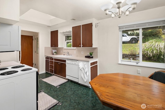 15544 Densmore Ave N, Shoreline, WA 98133 - kitchen featuring white appliances, light countertops, a sink, decorative backsplash, and a notable chandelier