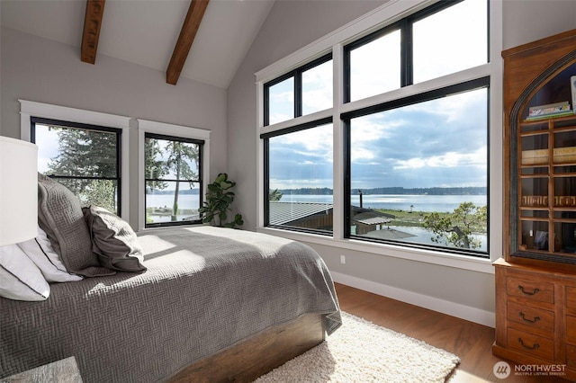 bedroom with a water view, wood finished floors, and baseboards