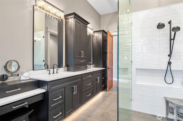 bathroom featuring a walk in shower, double vanity, and tile patterned flooring
