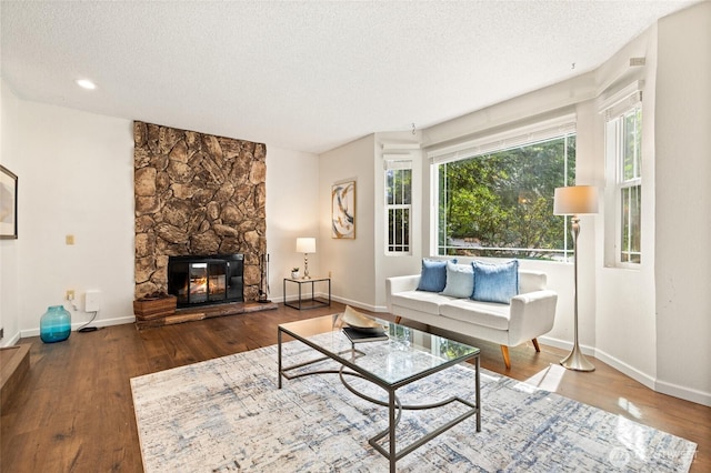 20817 29th Ave SE, Bothell, WA 98021 - living area with a textured ceiling, baseboards, a stone fireplace, and wood finished floors