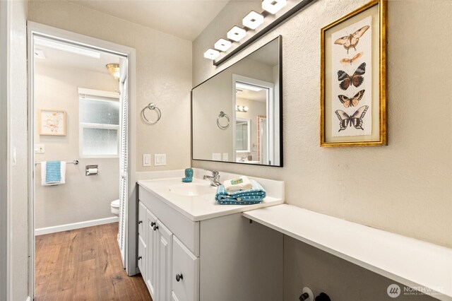 20817 29th Ave SE, Bothell, WA 98021 - bathroom featuring wood finished floors, vanity, toilet, and baseboards
