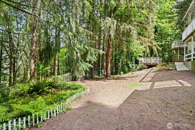20817 29th Ave SE, Bothell, WA 98021 - view of yard featuring a wooden deck, fence, a storage unit, an outbuilding, and a view of trees