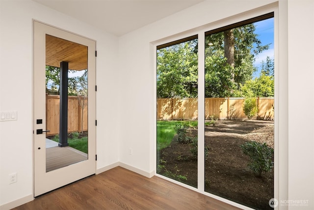 doorway featuring wood finished floors and baseboards