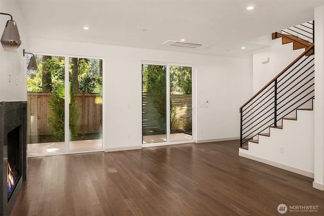 unfurnished living room with recessed lighting, stairway, wood finished floors, and baseboards