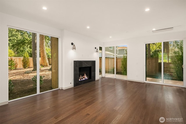 unfurnished living room featuring a wealth of natural light, wood finished floors, and recessed lighting