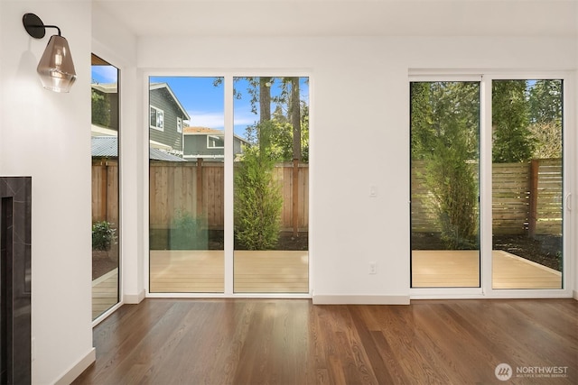 doorway featuring baseboards and wood finished floors