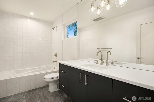 bathroom with vanity, tiled shower / bath, toilet, marble finish floor, and visible vents