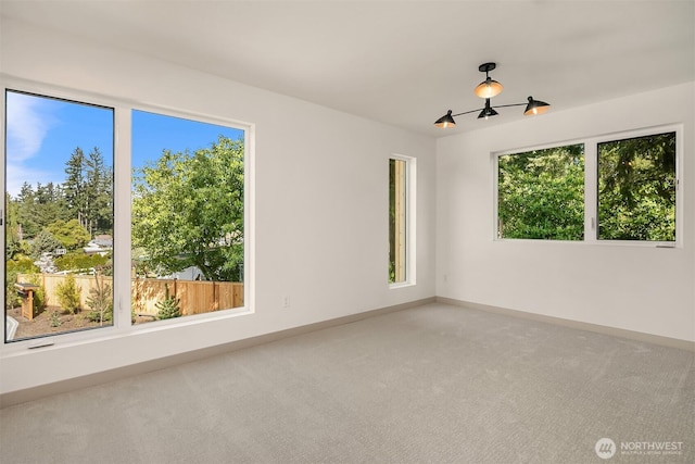 empty room with baseboards, carpet floors, and a healthy amount of sunlight