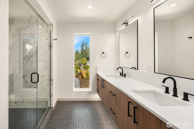 bathroom featuring baseboards, a marble finish shower, recessed lighting, and a sink