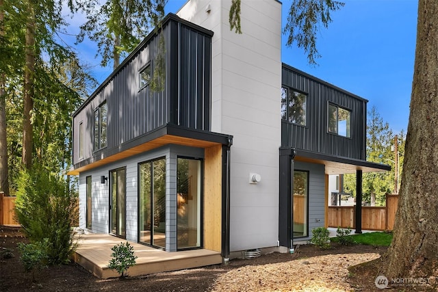 back of property featuring fence, a deck, and board and batten siding