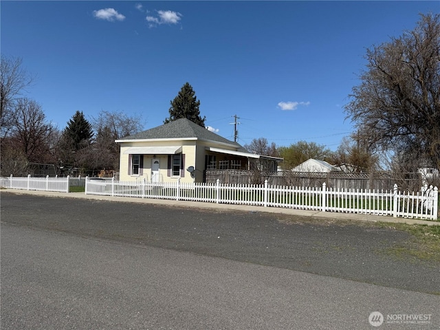 view of front of property featuring a shingled roof and a fenced front yard
