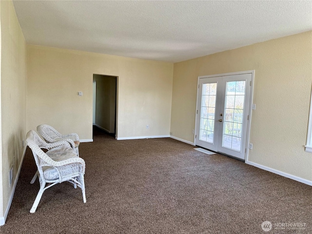 unfurnished room with dark carpet, a textured ceiling, french doors, and baseboards
