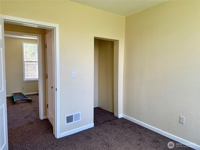 interior space featuring visible vents, baseboards, and carpet flooring