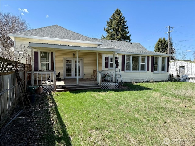 back of house with french doors, a fenced backyard, a shingled roof, and a lawn